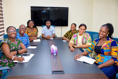 Members of the LCS team smiling around the boardroom table
