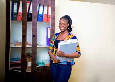 An LCS team member holding files beside a filing cabinet
